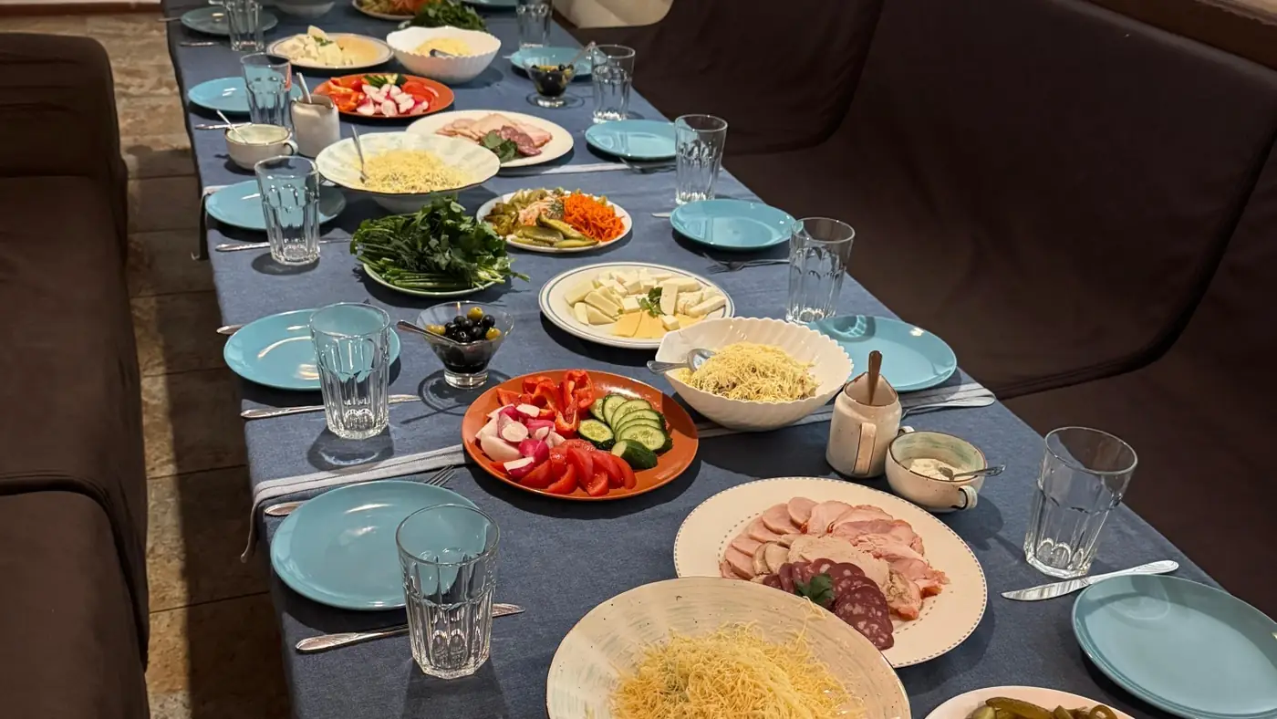 Сервировка стола с сыром, овощами и нарезкой